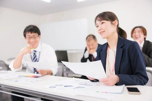 研修室の机で資料に目を通している女性
